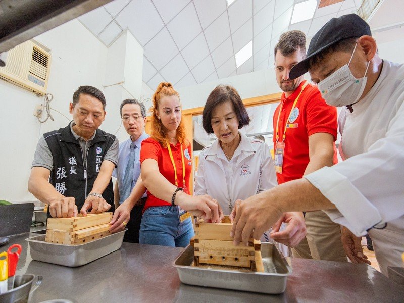 用豆腐和羅馬尼亞團員交流互動，宣揚台灣特色小吃