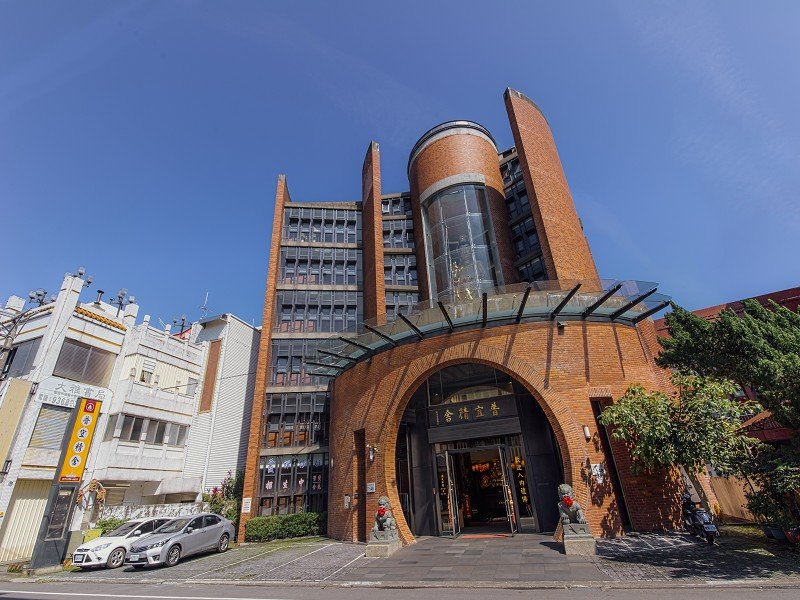 圖一普宜精舍外觀雄偉，六層樓挑高的圓弧型紅磚獨棟建築，宛如層層蓮花瓣，清淨莊嚴